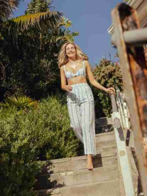A pretty blonde girl walking down stairs in summer.