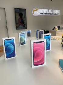 Apple phones in their case sitting on a desk at a store.