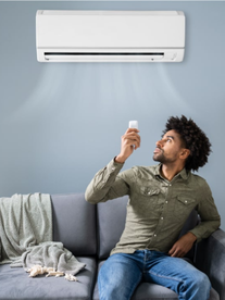 A man sitting on a couch turning on his Sucasa air conditioner.